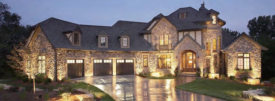 A landscaped home at dusk with illuminated planting and architectural details